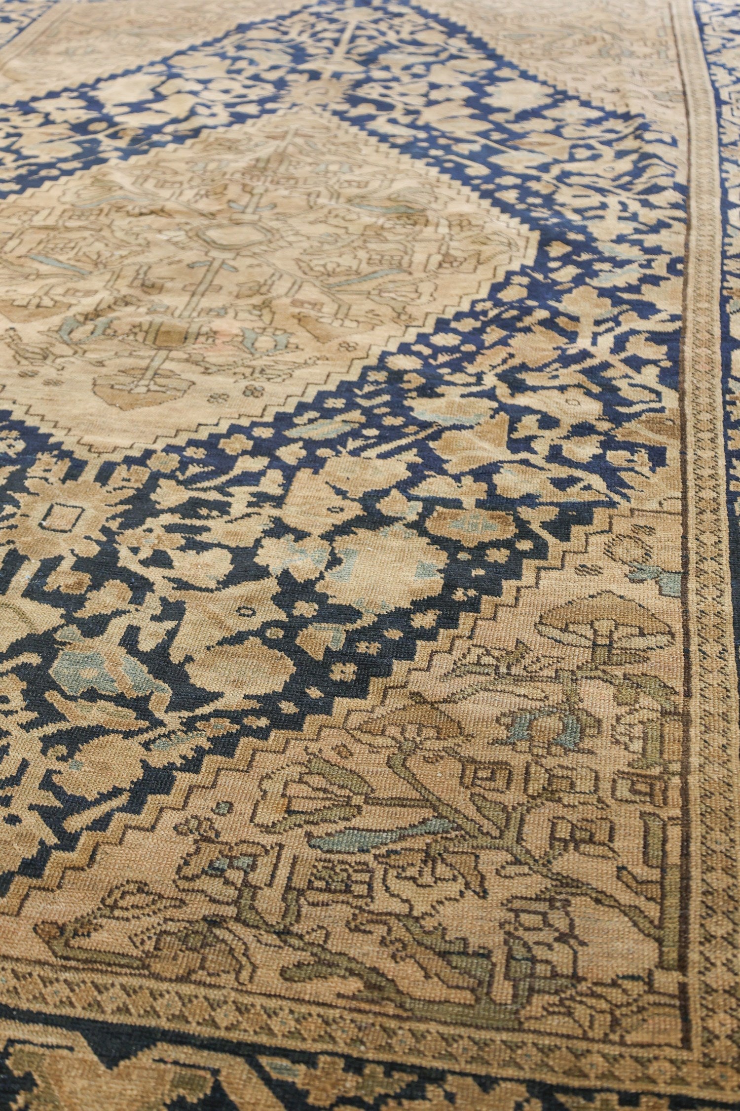 Handwoven antique Malayer Sarouk rug detail, beige and navy pattern.
