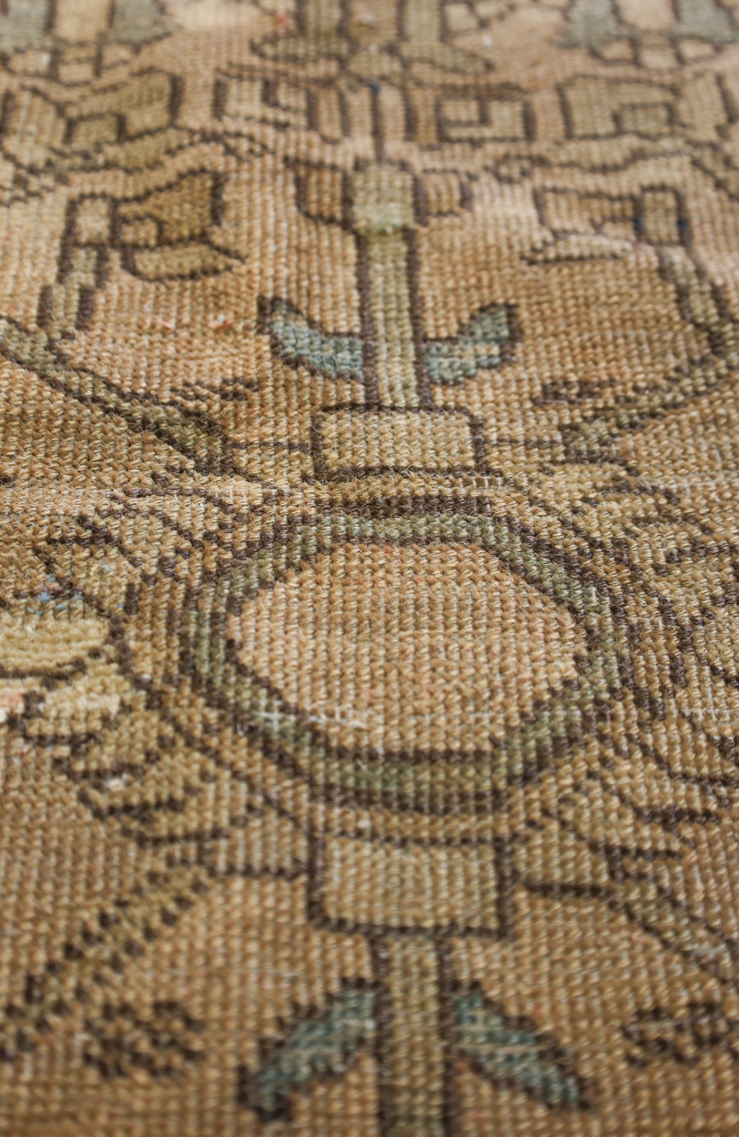 Close-up view of a handwoven rug's detailed texture, showcasing earthy tones and intricate pattern.
