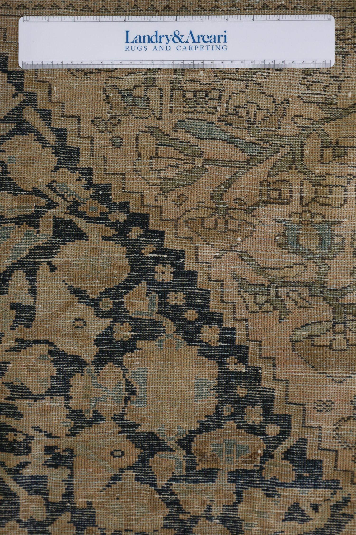 Close-up detail of antique Malayer Sarouk rug's handwoven texture, showcasing its beige and dark navy pattern.
