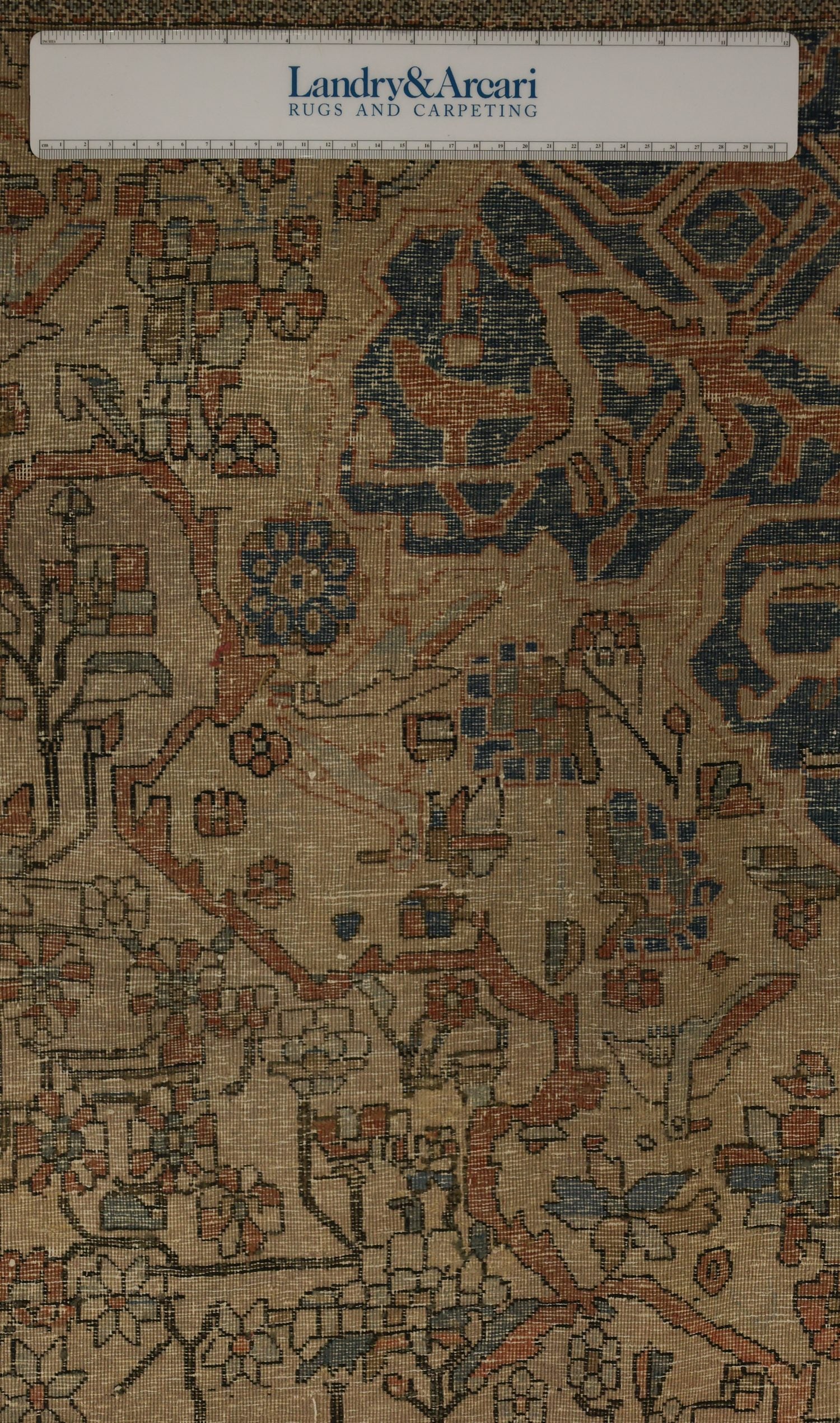 Detailed close-up of antique Kashan rug's intricate, handwoven pattern in muted reds and blues.
