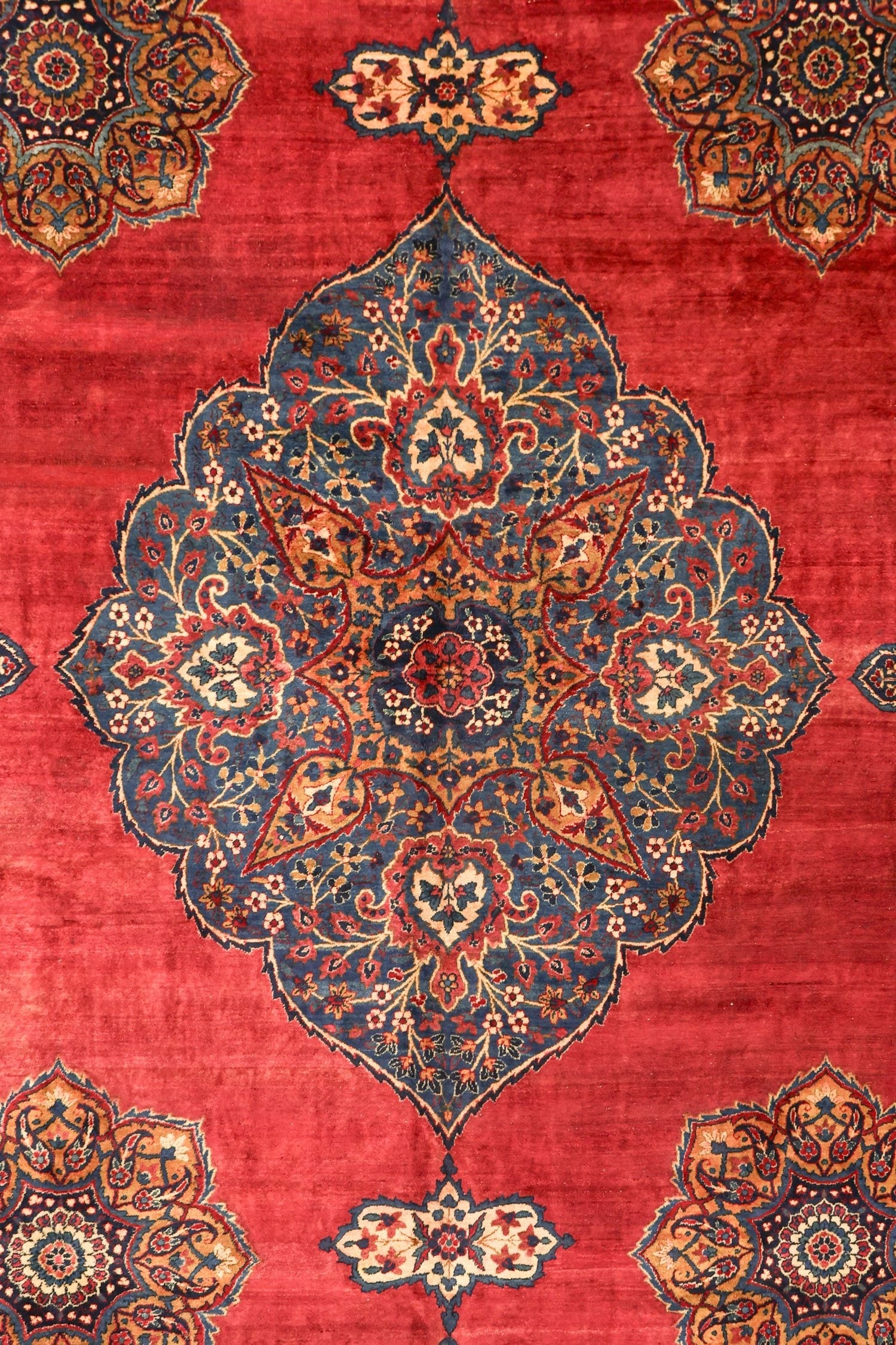 Intricate floral detail on a vintage red rug, showcasing traditional Persian design.
