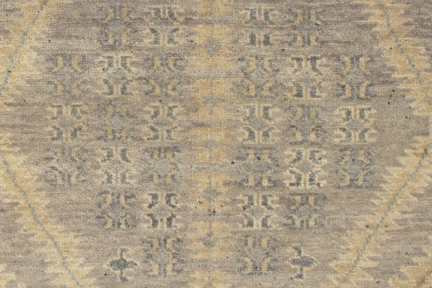 Handwoven rug detail, neutral tones, intricate tribal pattern.
