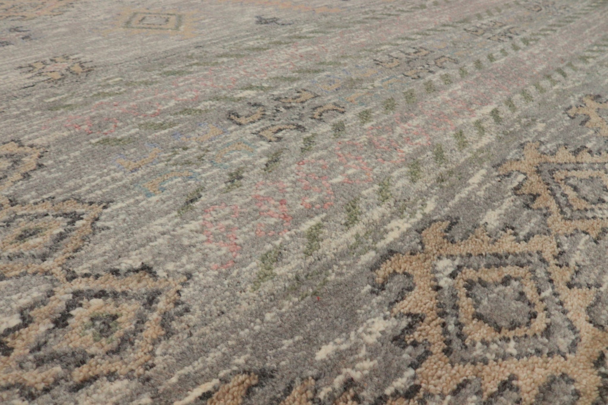 Close-up of handwoven rug’s neutral-toned pattern, showcasing textured wool fibers.
