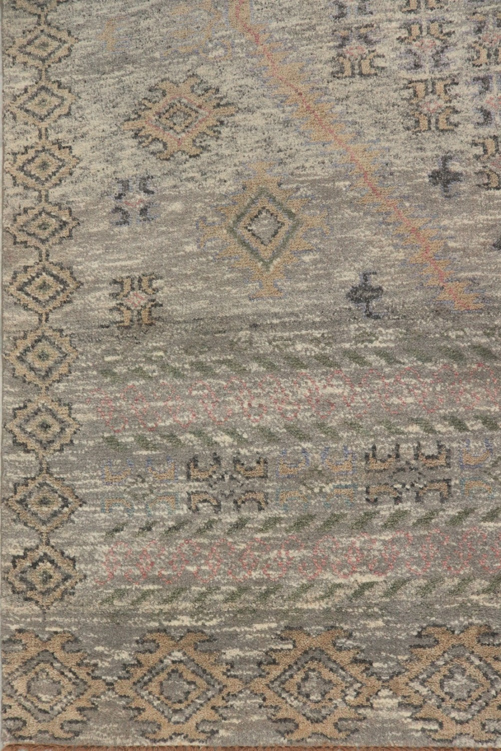 Handwoven rug detail: neutral-toned, tribal pattern with geometric designs.
