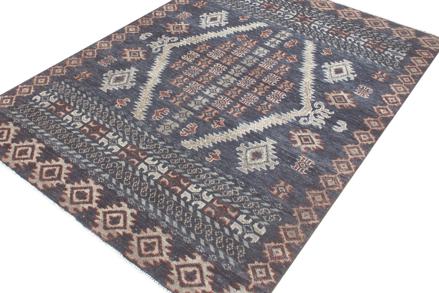 Handwoven rug with intricate tribal pattern in dark gray, beige, and rust tones.
