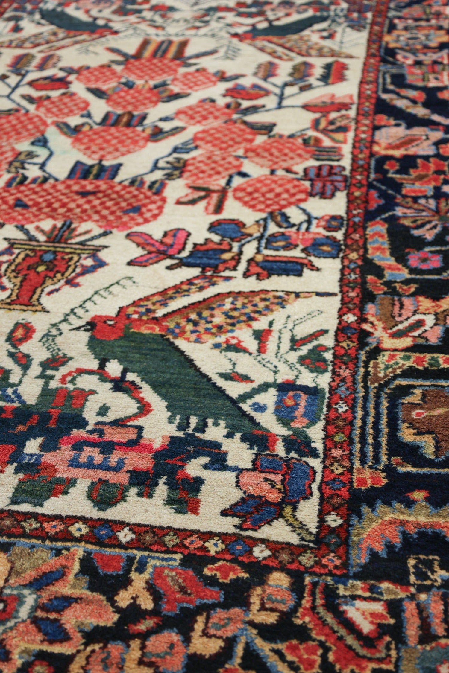 Handwoven rug detail:  Antique Bakhtiari design, featuring vibrant red, blue, and cream floral patterns on a dark border.
