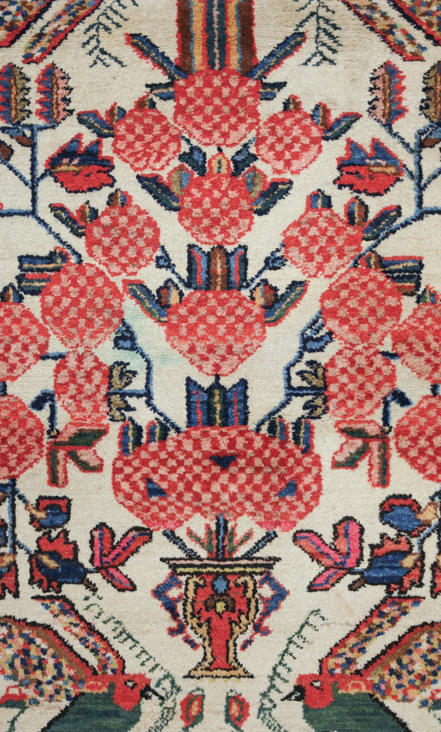 Antique handwoven rug detail: cream background, red floral motif, and vibrant blue-green accents.
