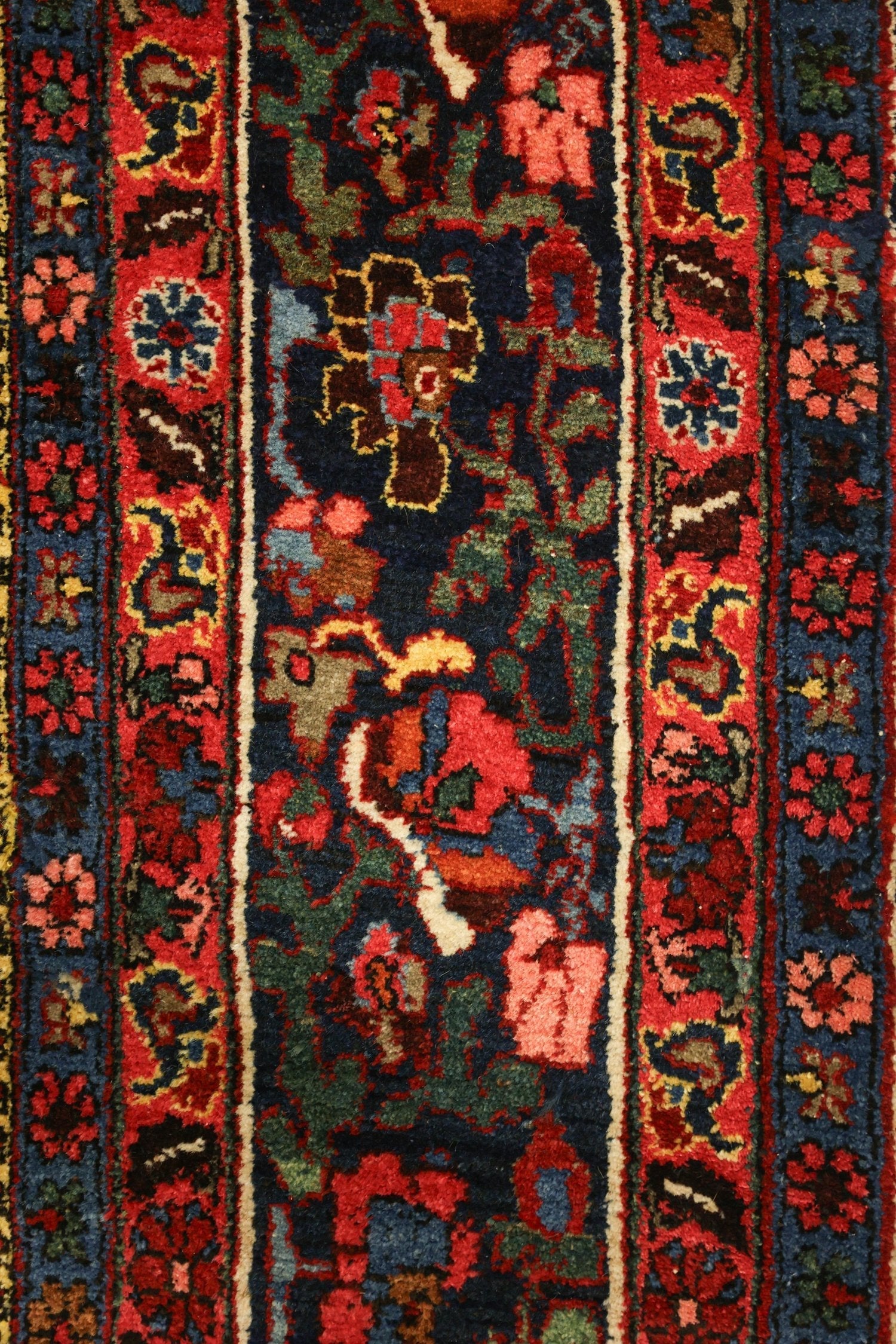 Intricate detail of a handwoven tribal rug, rich red and deep blue tones.
