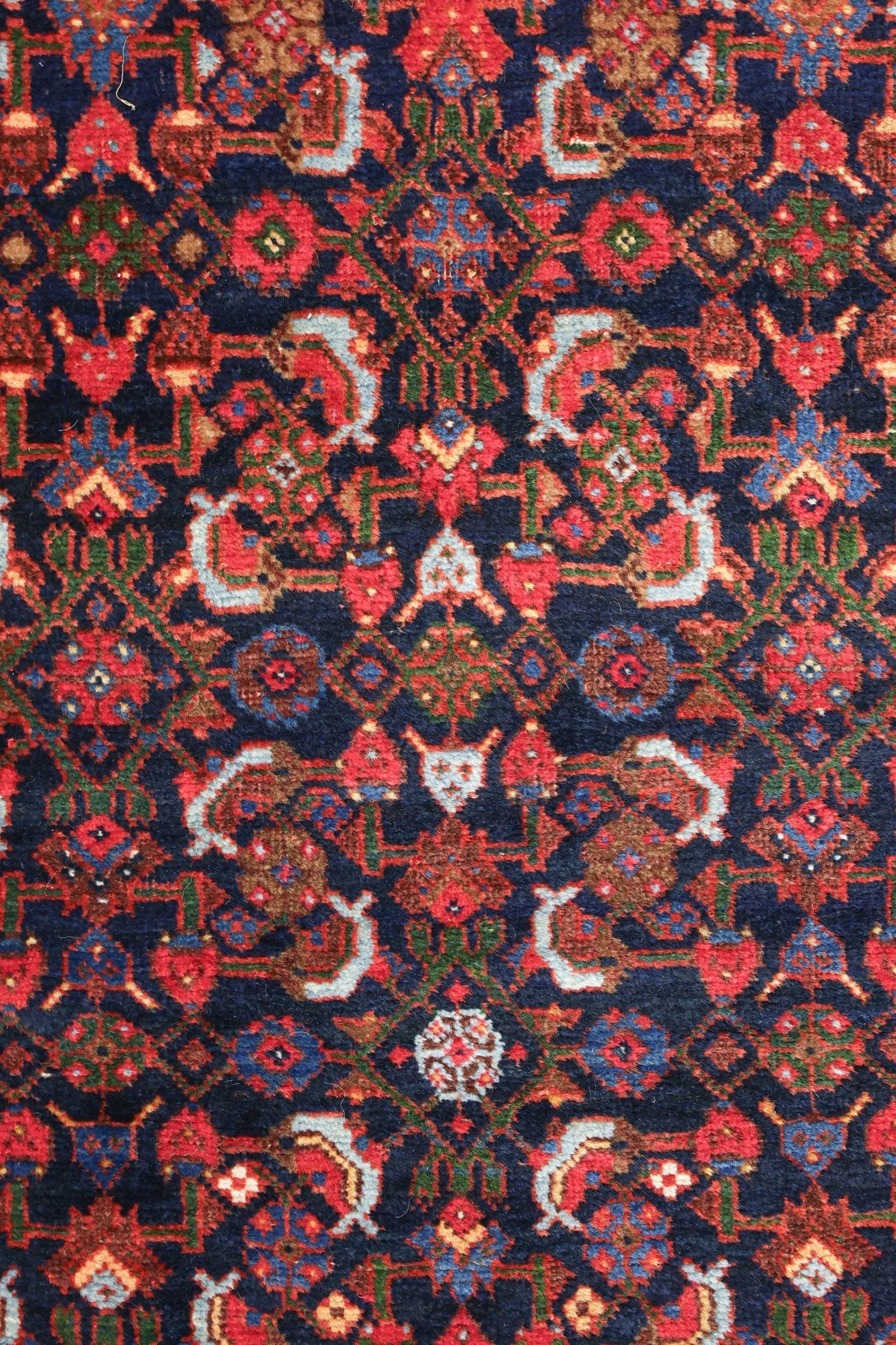 Intricate detail of a handwoven rug in deep blues, reds, and greens.
