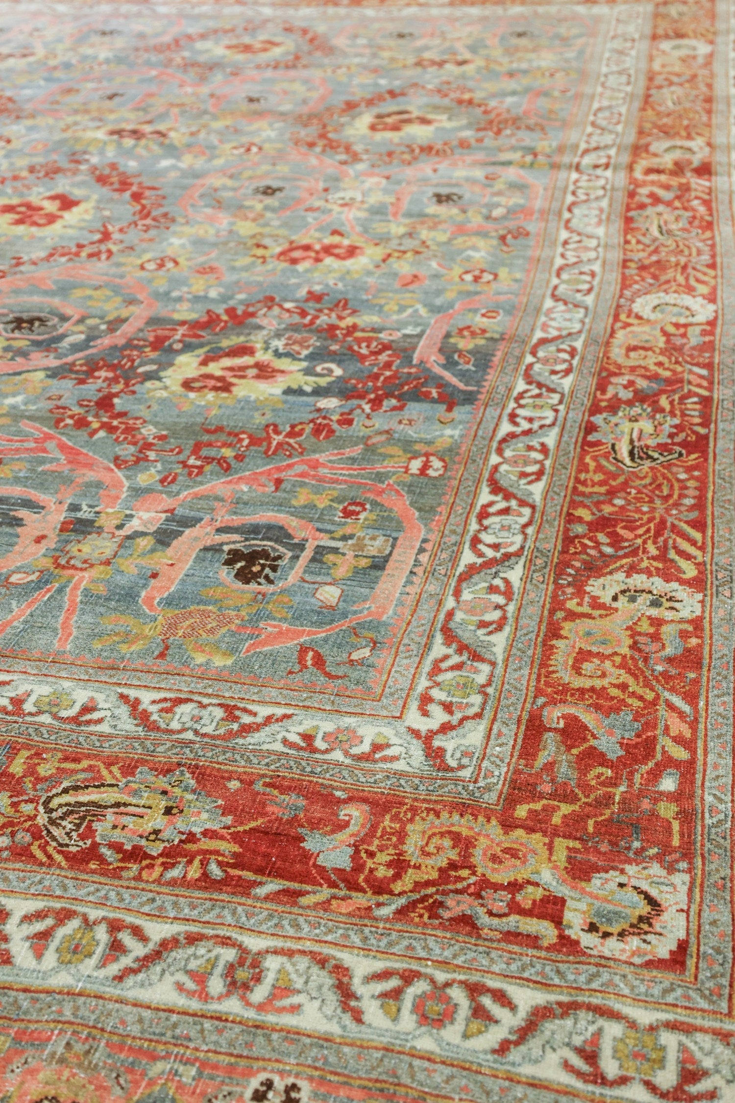 Antique Bijar rug detail: handwoven, red and gray floral pattern.
