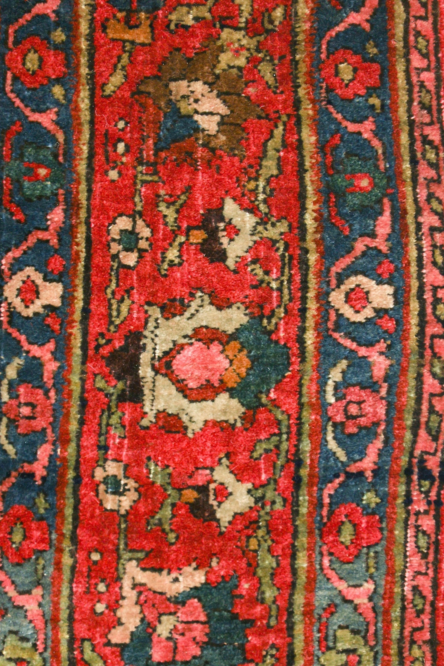 Detail of antique Bijar rug; rich red and blue handwoven pattern.
