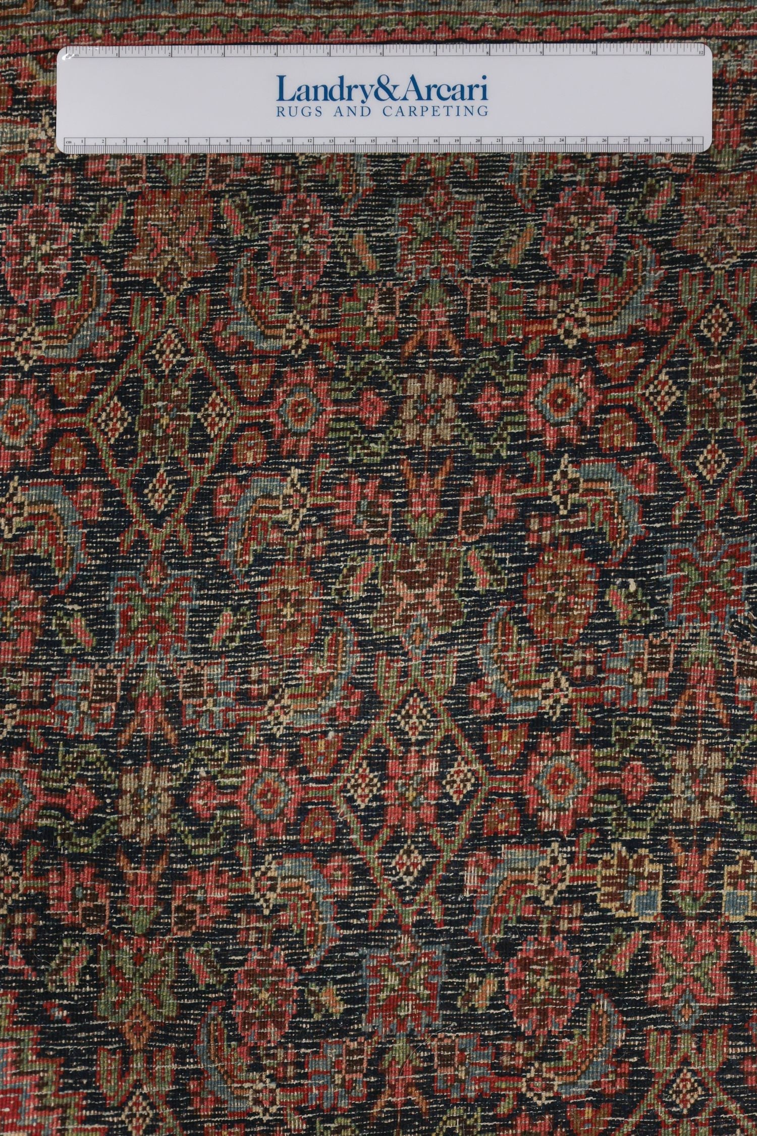 Detailed close-up of antique Bijar rug's intricate, multicolored design.
