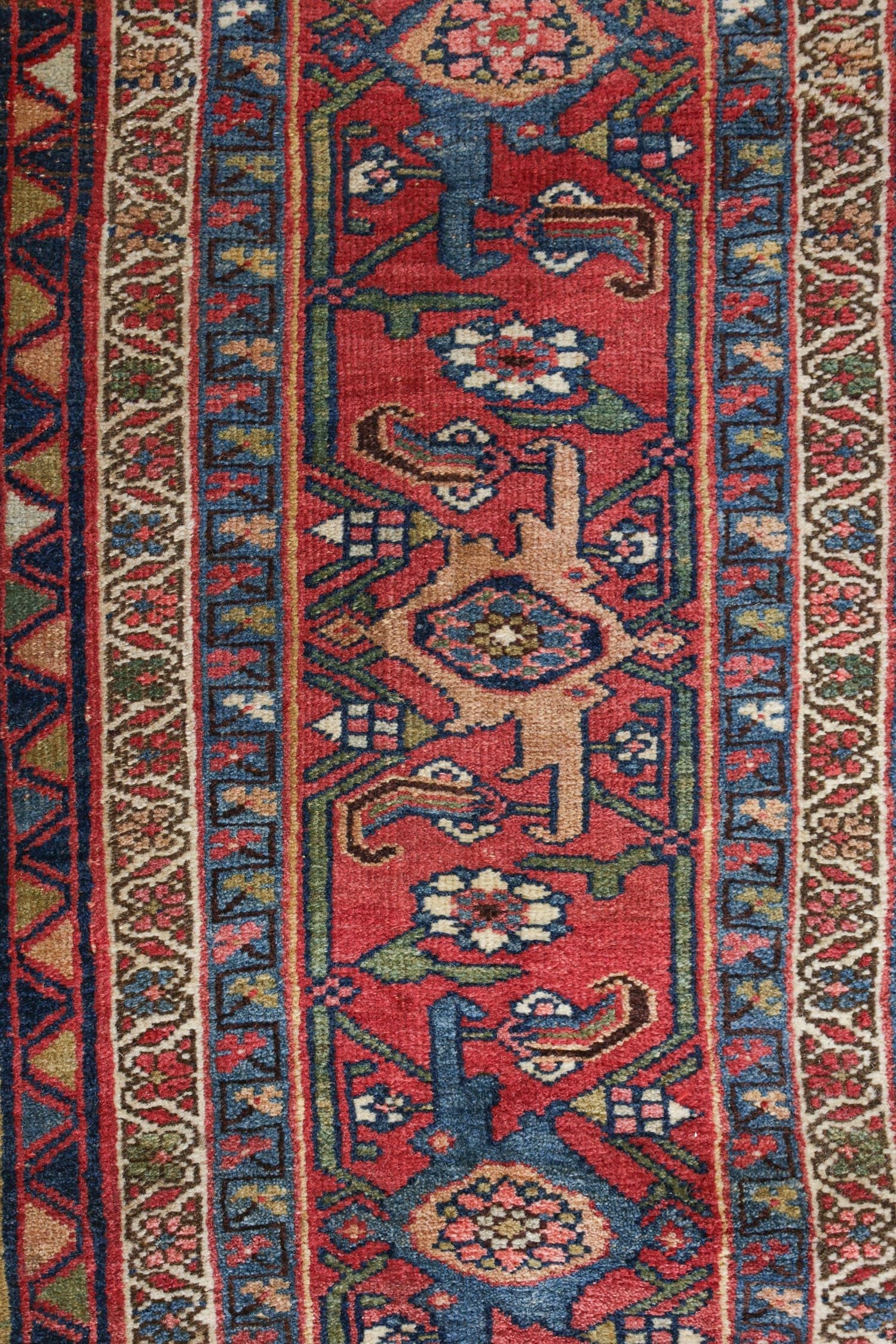 Close-up detail of a handwoven rug's intricate, multicolored pattern.
