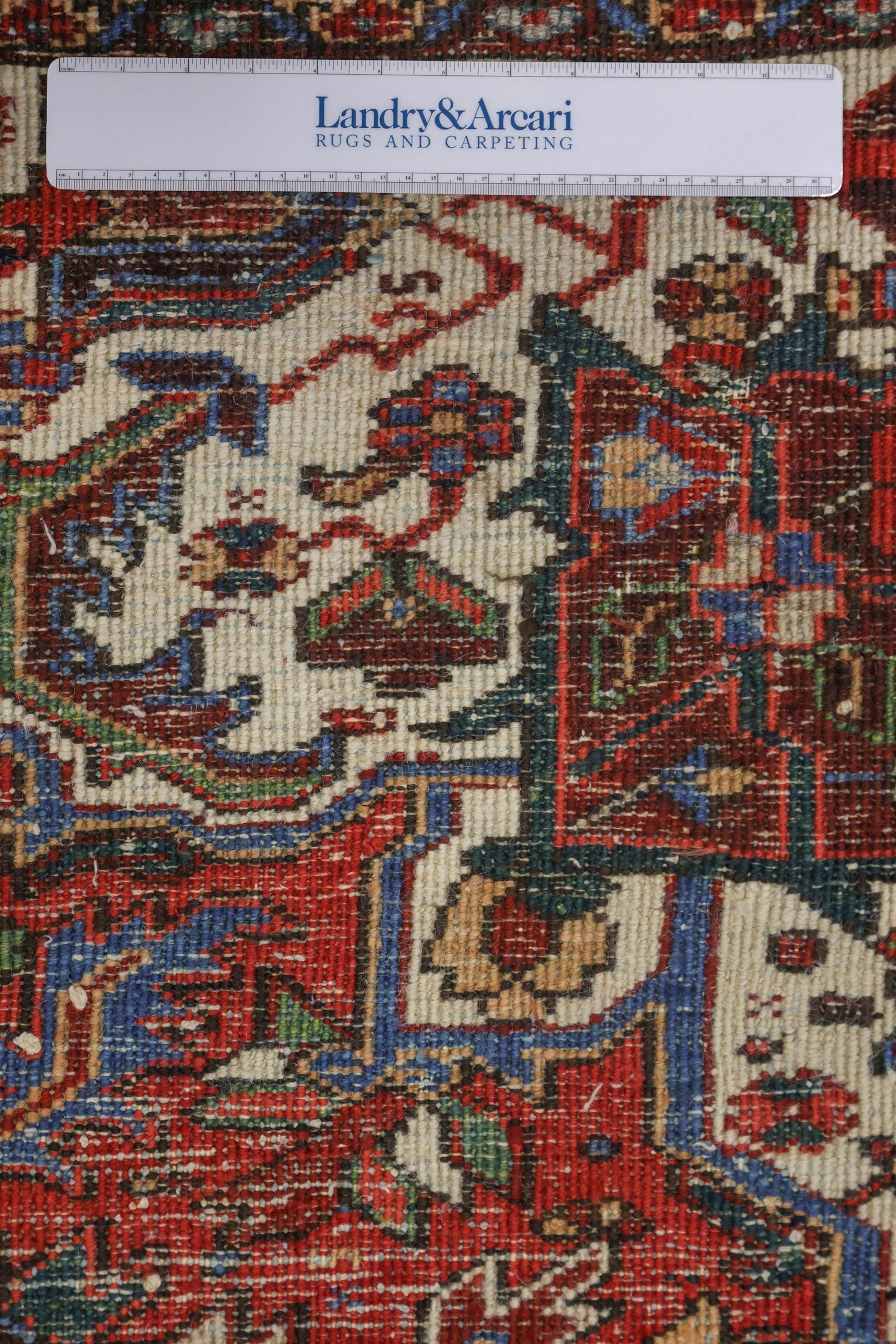 Close-up detail of antique Heriz rug's handwoven, multicolored pattern.
