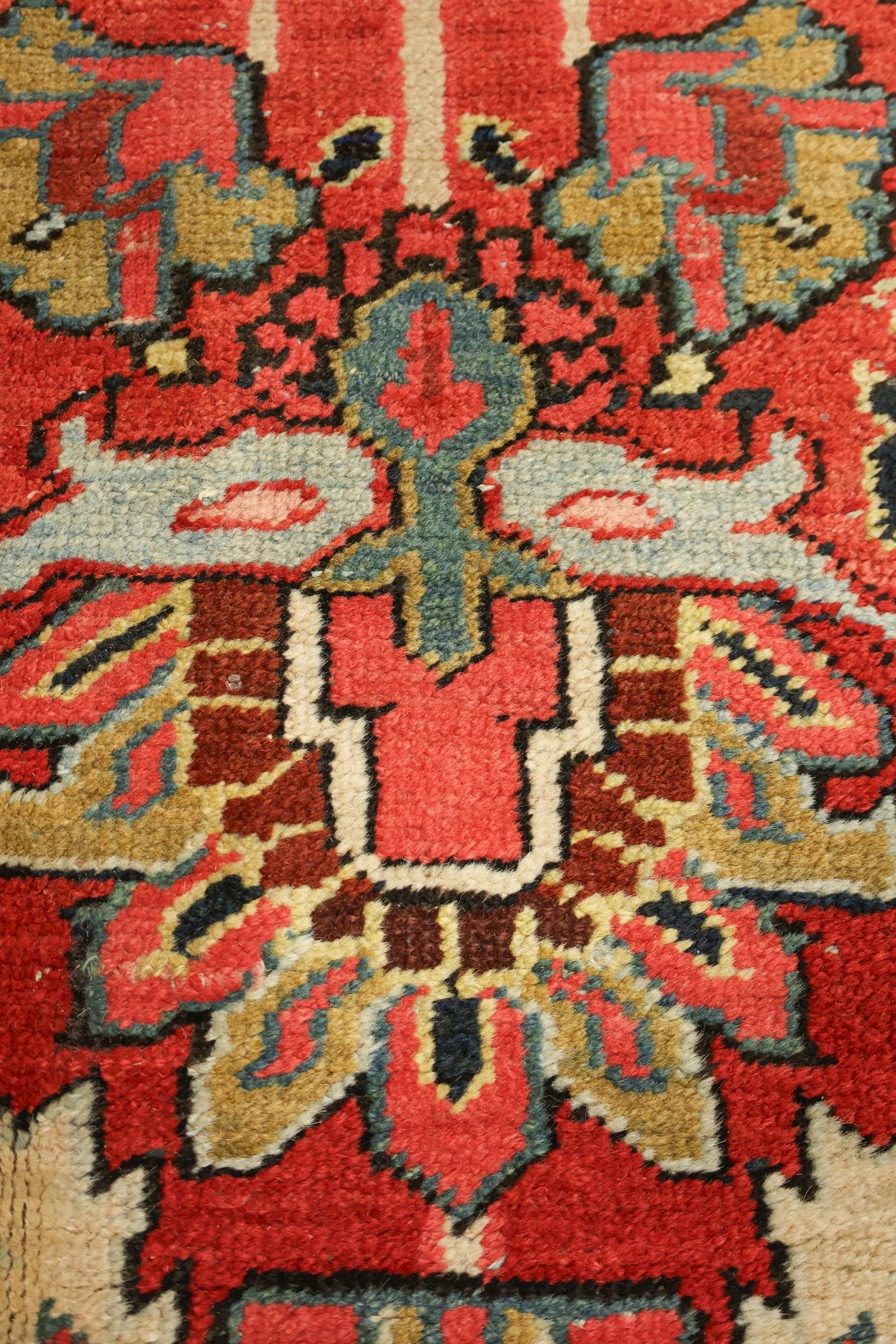 Close-up detail of a handwoven rug's intricate, multicolored pattern.
