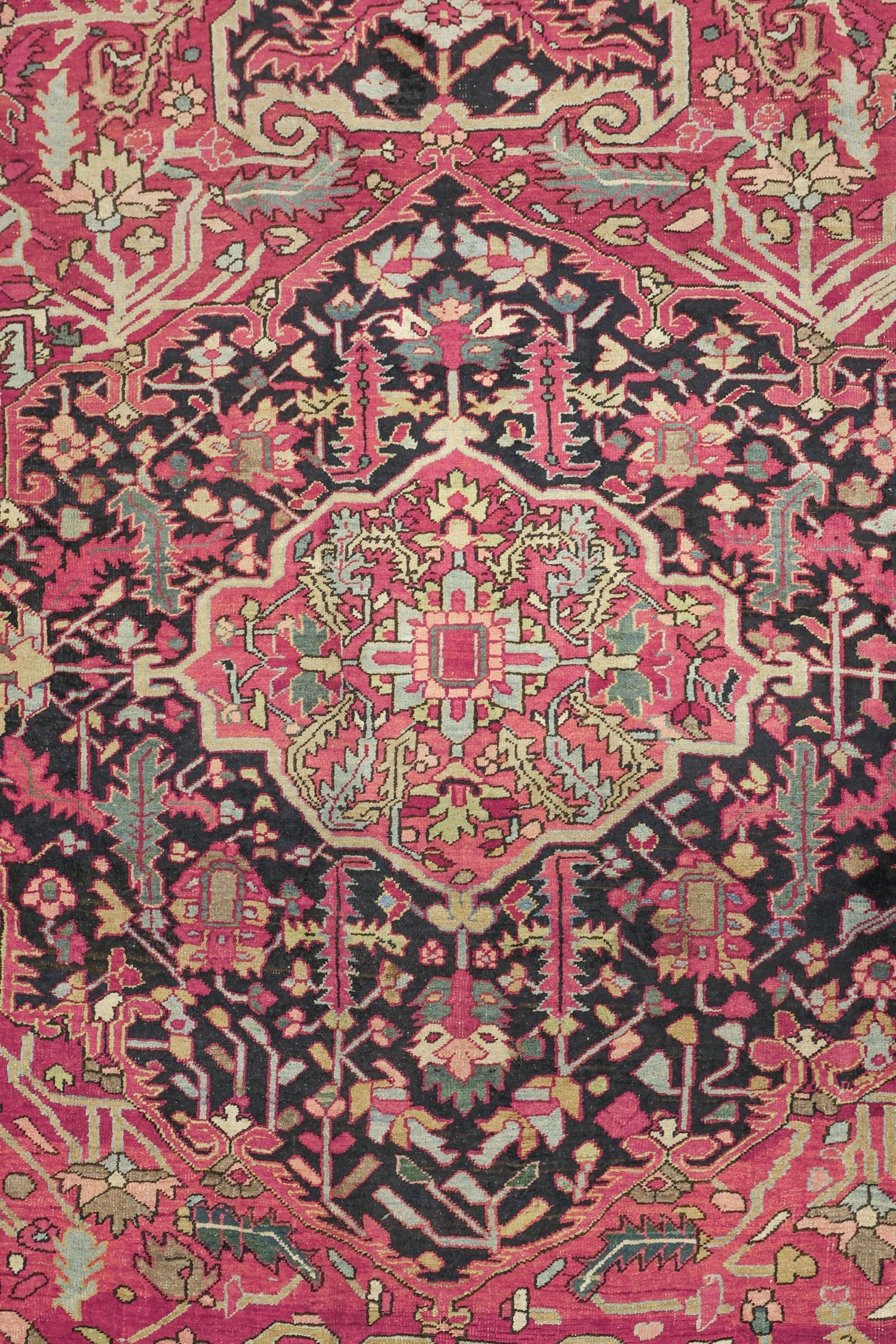 Intricate detail of a vintage handwoven rug, showcasing a red and black floral pattern.
