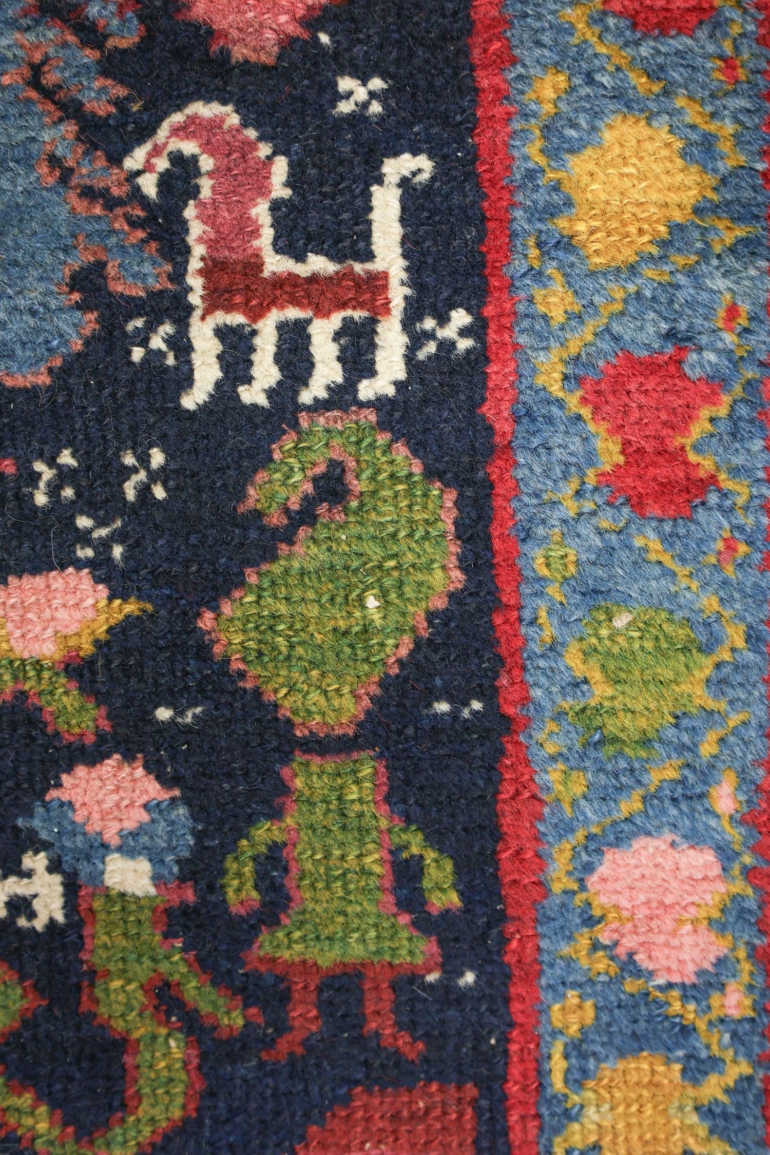 Handwoven tribal rug detail:  vibrant blues, reds, and greens in a detailed, antique Malayer design.
