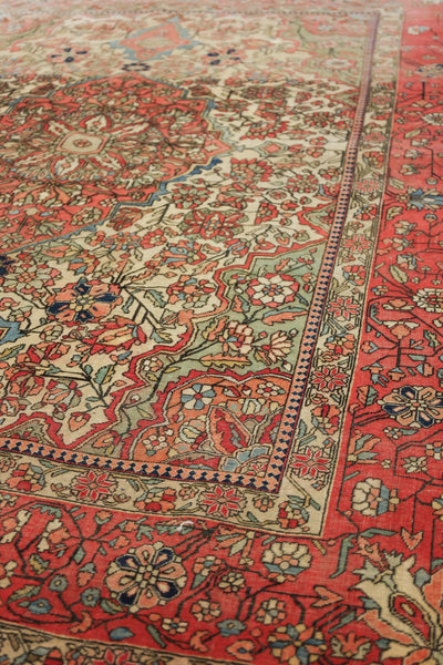 Detail of antique tribal rug with red, beige, and teal floral pattern.
