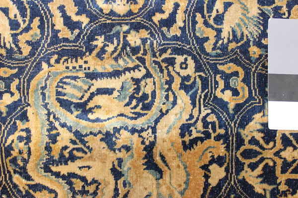 Detail of antique Amritsar rug, showcasing a handwoven design in blue and beige tones.
