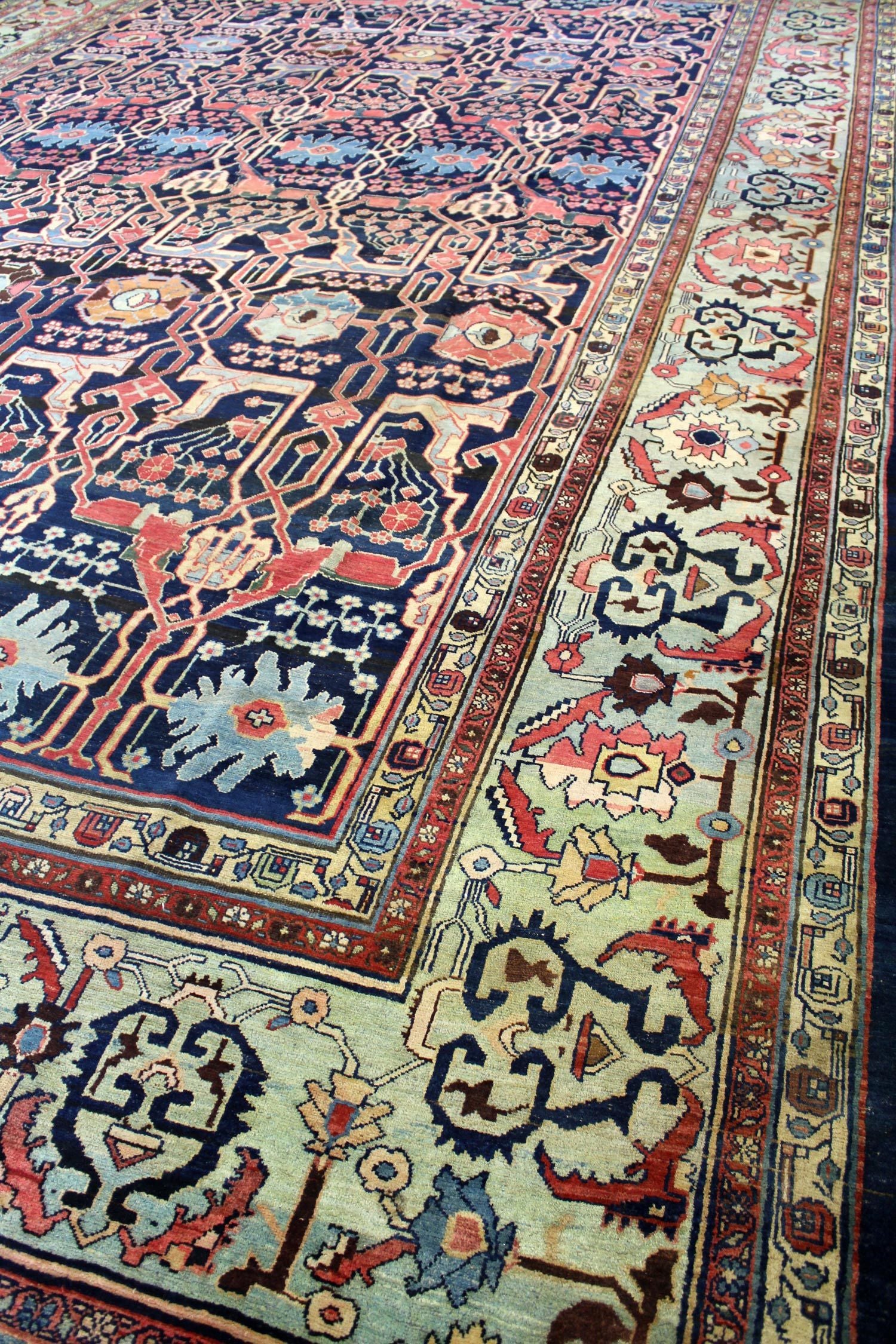 Handwoven Bijar rug detail, showcasing intricate floral and geometric patterns in navy, red, and beige.
