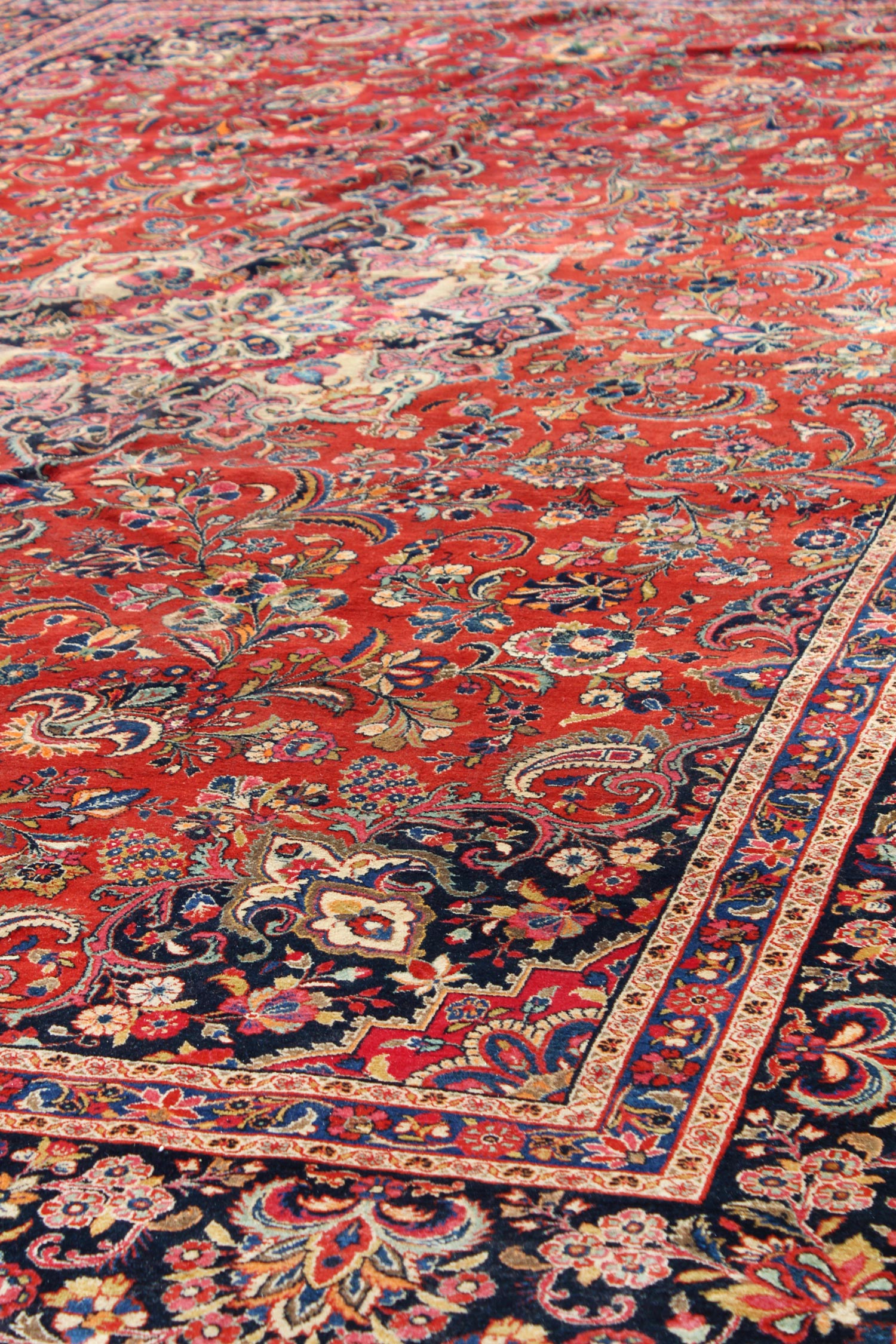 Intricate floral detail on a traditional red and navy rug.
