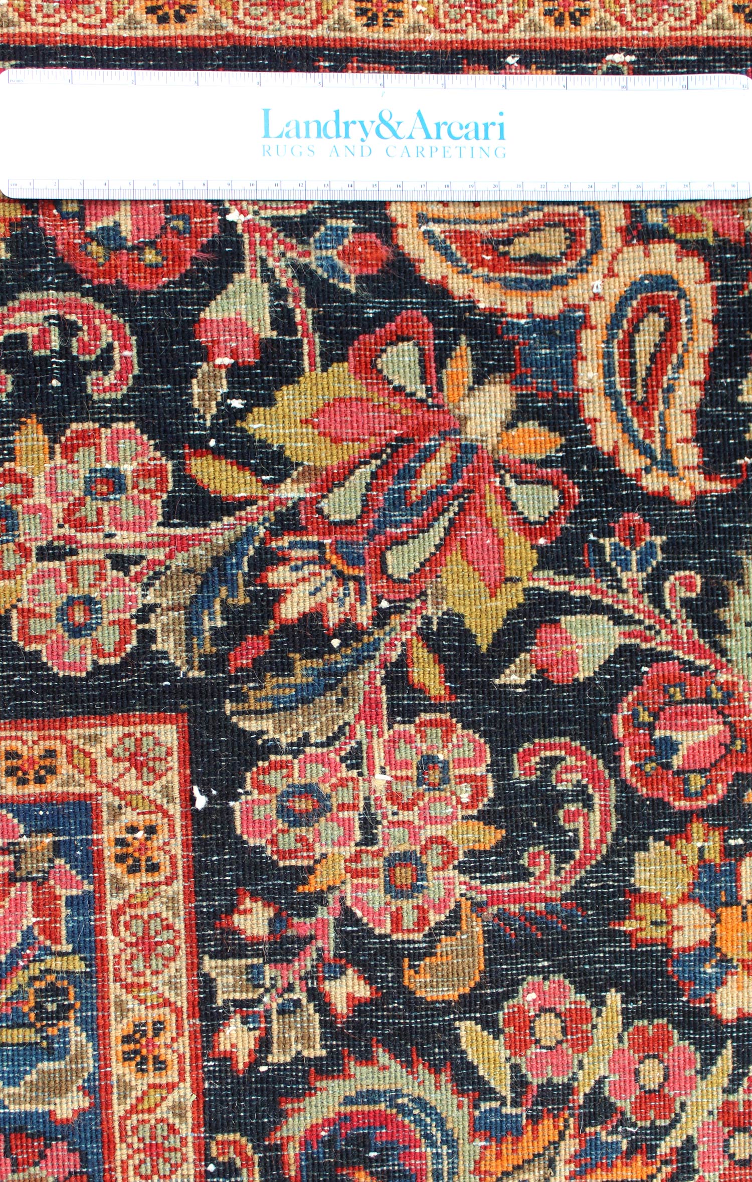 Detailed close-up of an antique Ekbatan rug's handwoven floral pattern, showcasing rich colors and intricate detail.
