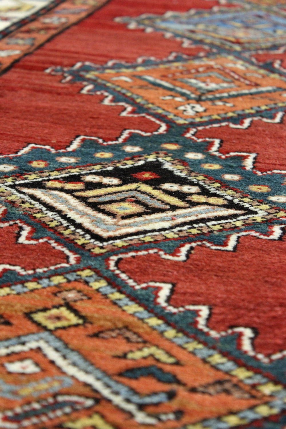 Close-up of a handwoven rug's intricate, colorful pattern.
